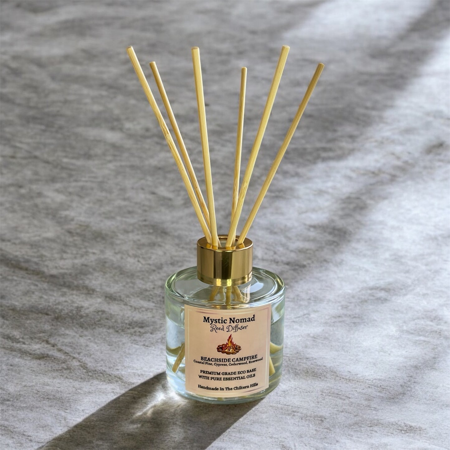 Beachside Campfire reed diffuser by Mystic Nomad with reeds displayed, luxury eco-friendly aromatherapy in Italian glass jar.