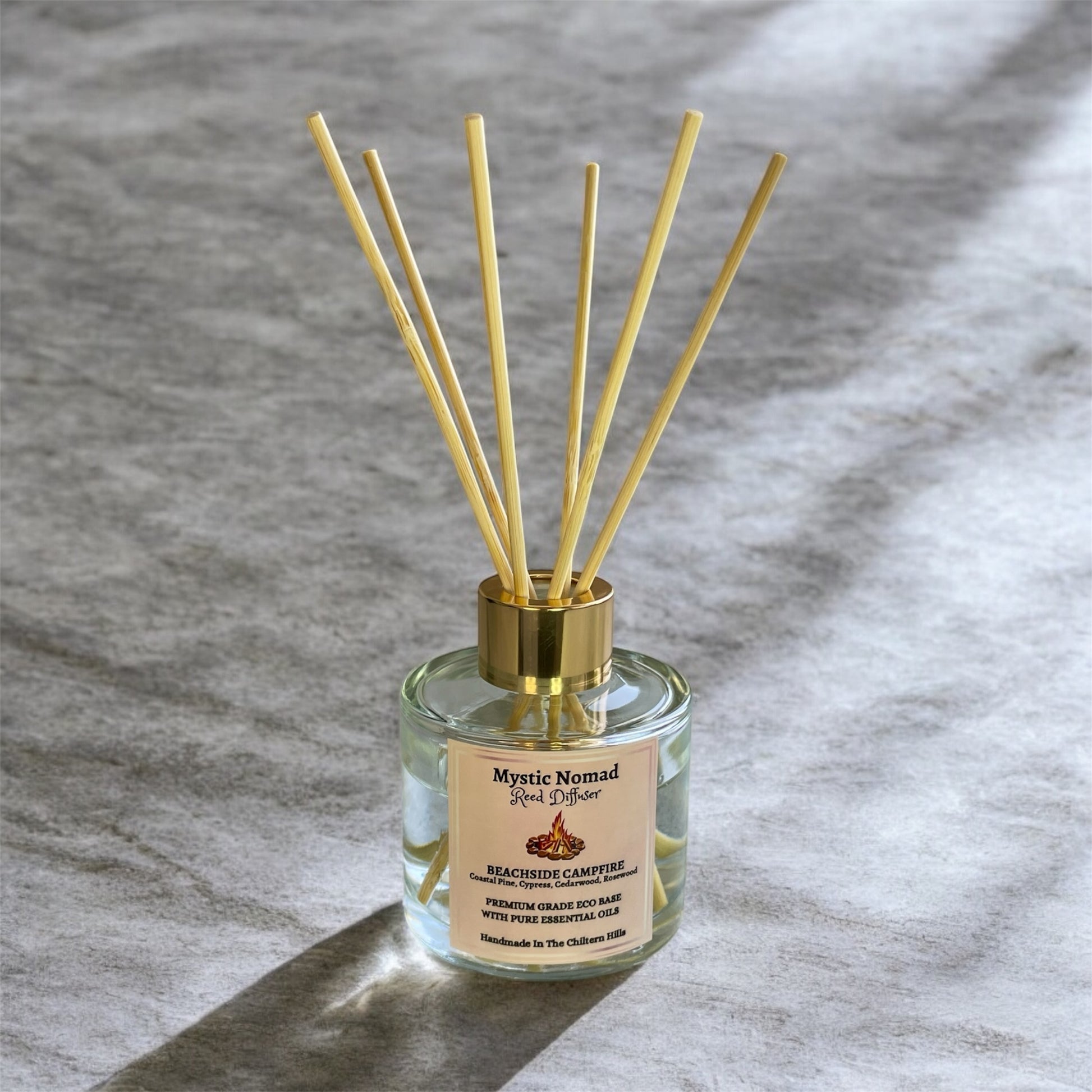 Beachside Campfire reed diffuser by Mystic Nomad with reeds displayed, luxury eco-friendly aromatherapy in Italian glass jar.