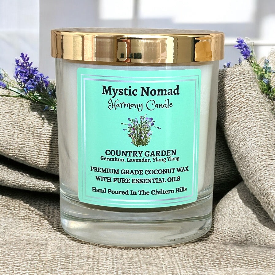 Mystic Nomad's Country Garden Candle surrounded by fresh flowers, showcasing its natural, floral-inspired scent of geranium, lavender, and ylang-ylang essential oils.