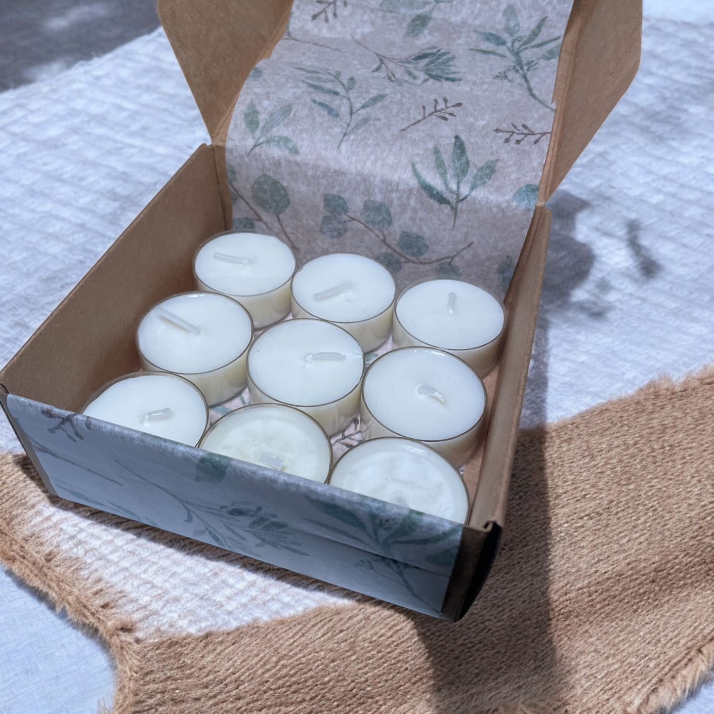 Open box showing 9 Wildflower Meadow scented tea lights, perfect for aromatherapy rituals and emotional balance.