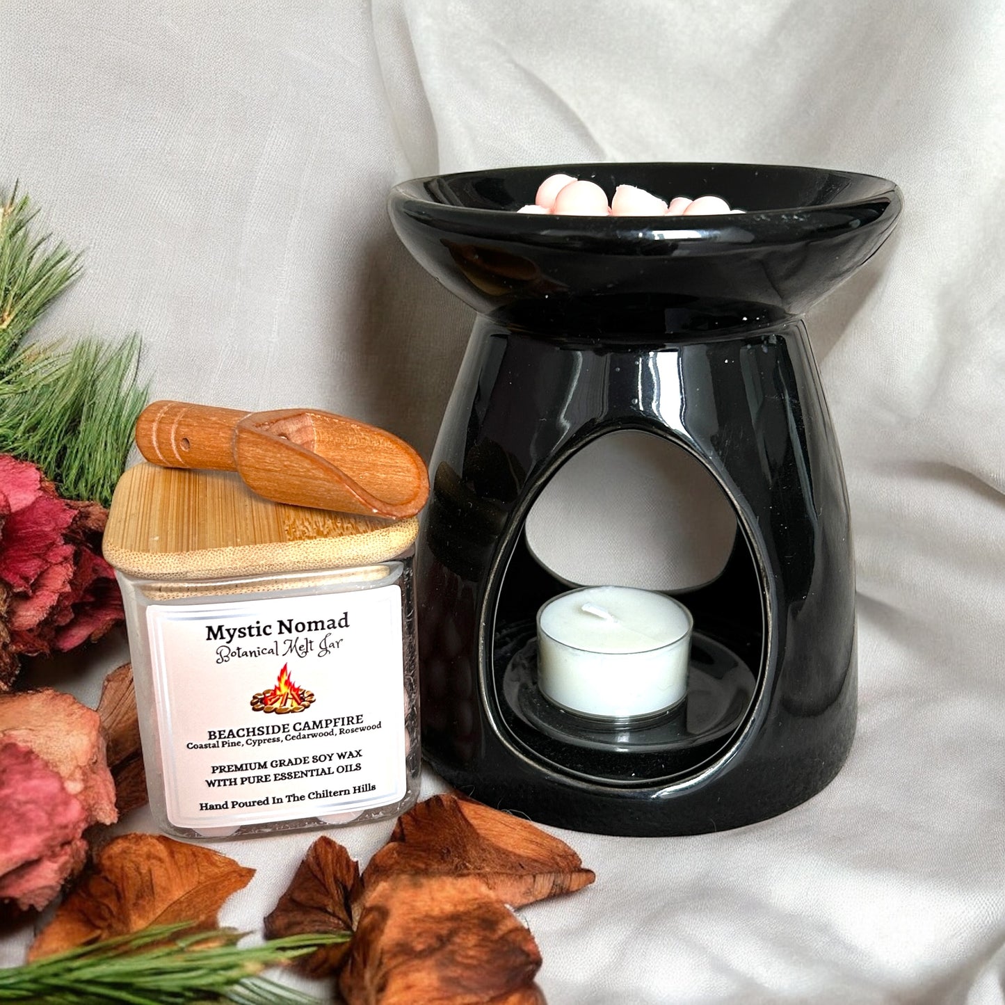 Botanical wax melt releasing smoky-woody, coastal pine aroma in a ceramic burner