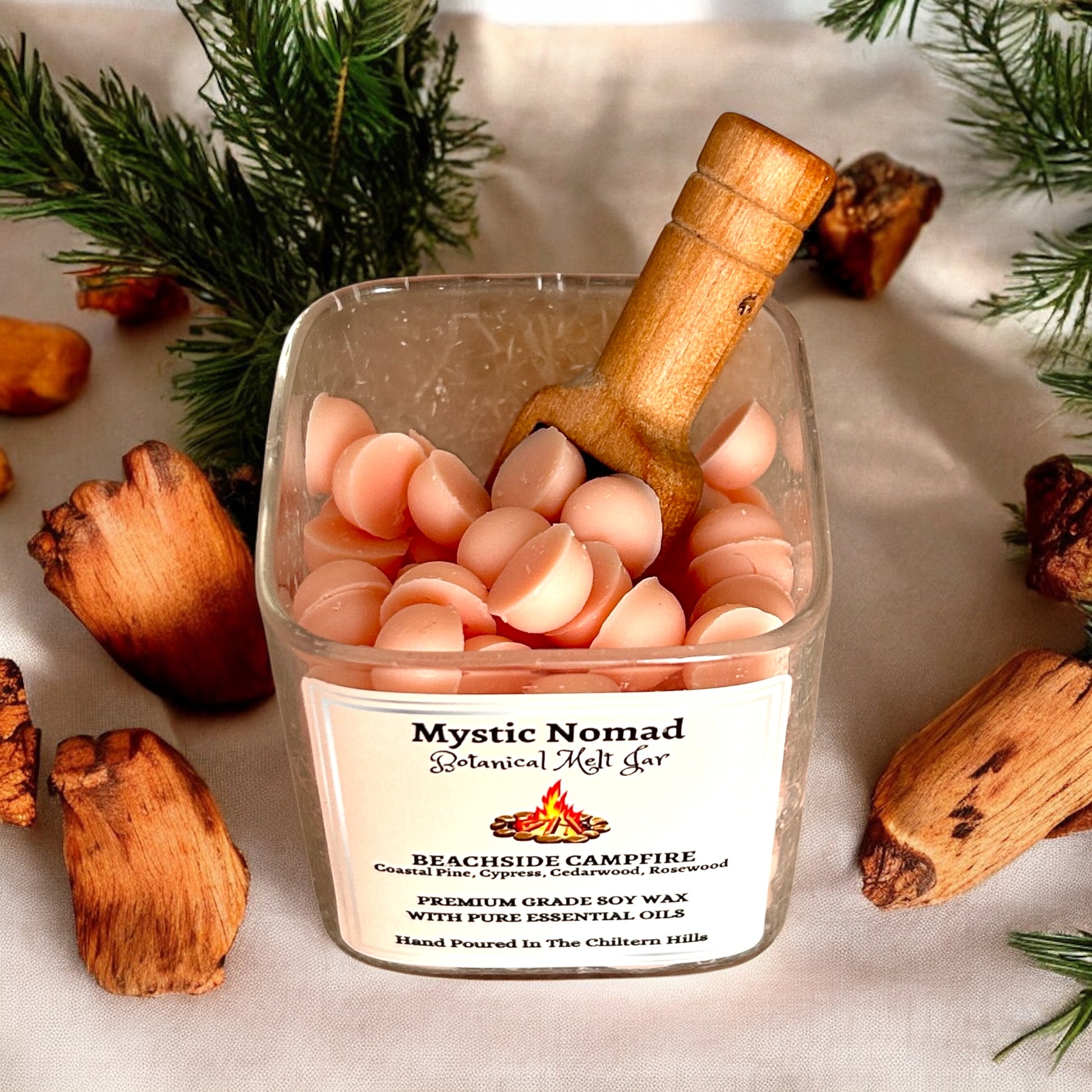 Luxury glass jar with gold lid, showing wax melts inside and wooden spoon for scooping