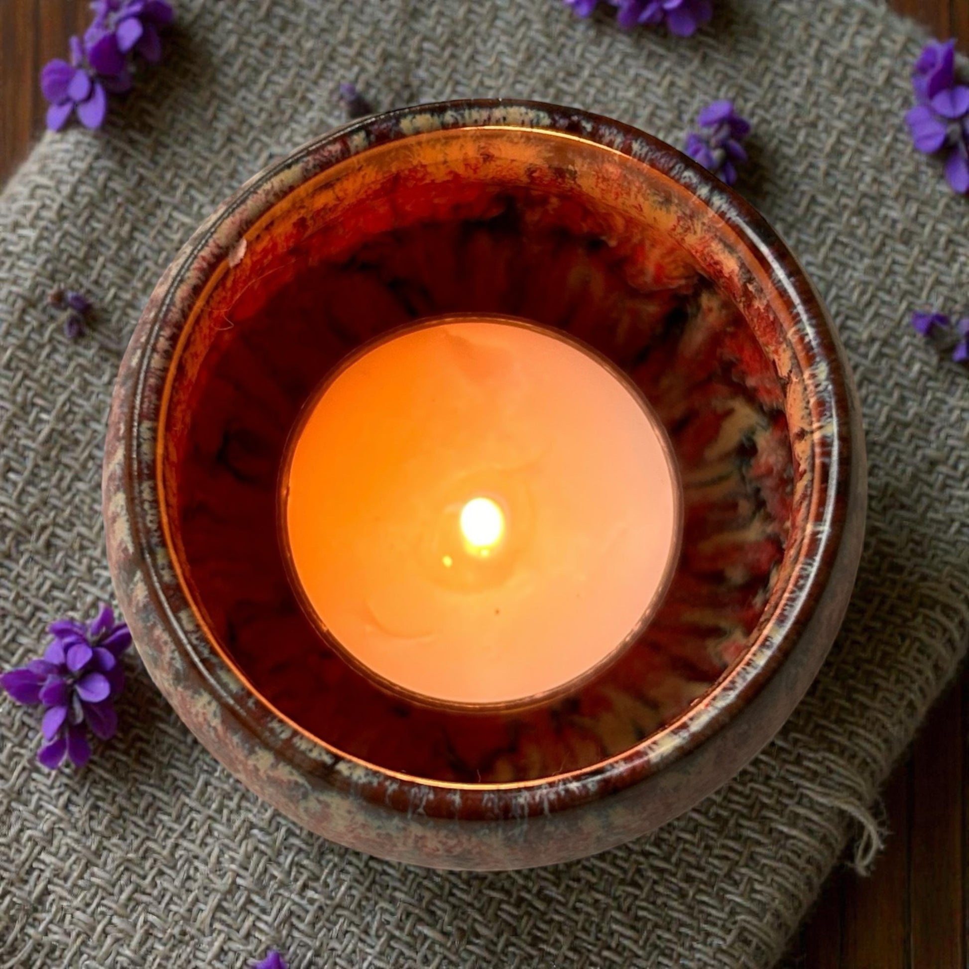 Dream Mist tea light burning in a ceramic holder, releasing essential oil aromas for relaxation and restful sleep.