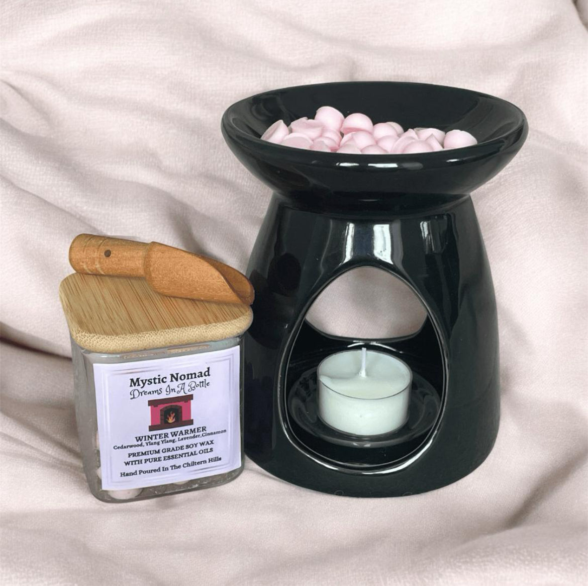 Wax melt burner with botanical aromatherapy candle jar, releasing soothing essential oil fragrances.