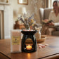 Lifestyle shot of luxury wax melt burner with aromatherapy candle and essential oils, creating a calming home atmosphere.