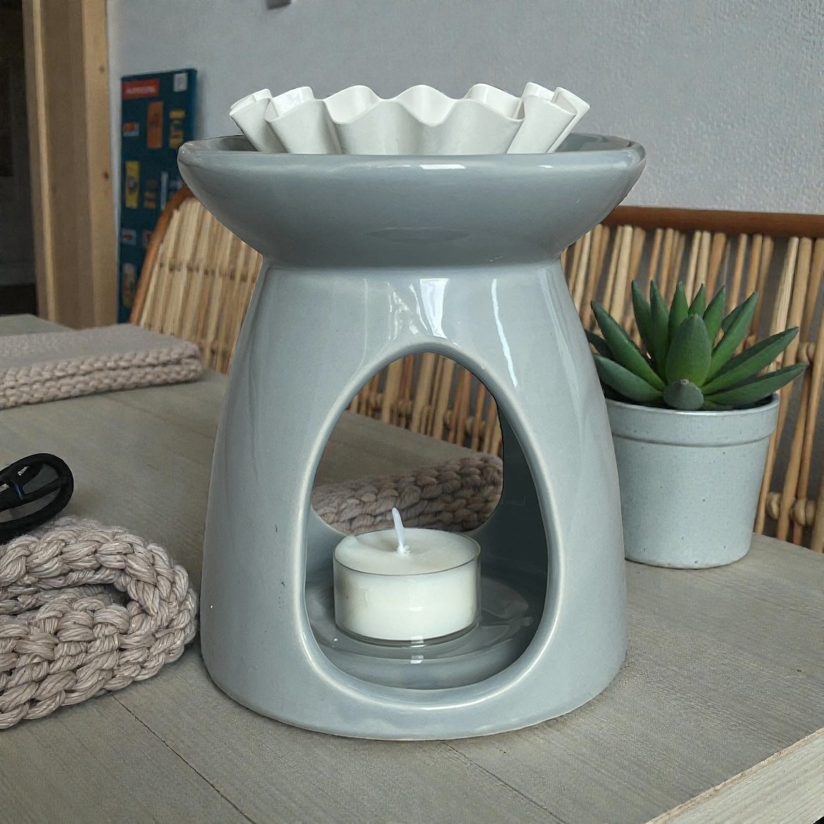 Coconut and rapeseed wax tea light by Mystic Nomad Aromatherapy placed in a grey wax melt burner.