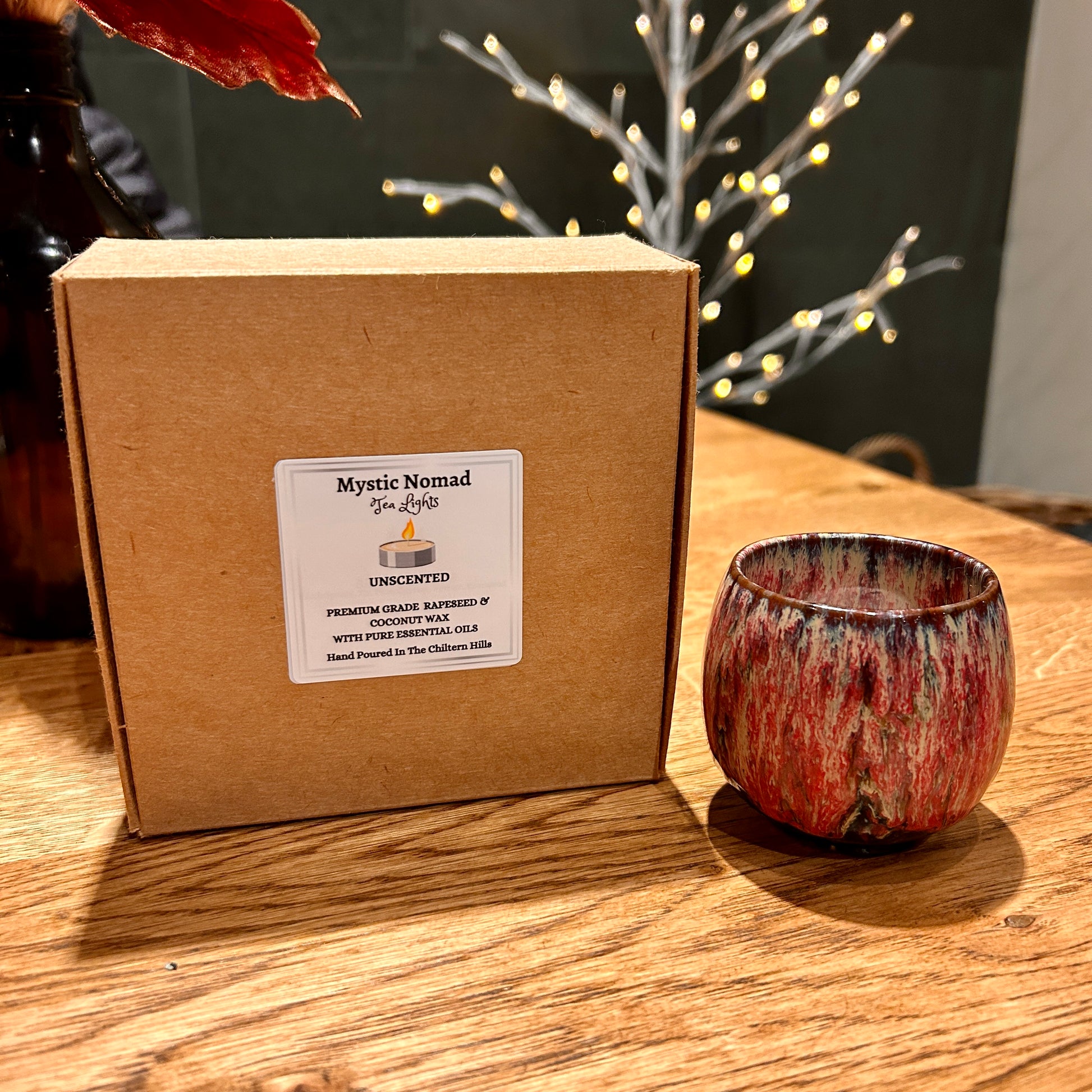 Box of eco-friendly Mystic Nomad Aromatherapy tea lights displayed with a ceramic tea light holder.