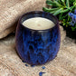 Hand-poured Reset and Unwind coffee cup candle styled for a cosy, relaxing aromatherapy moment.
