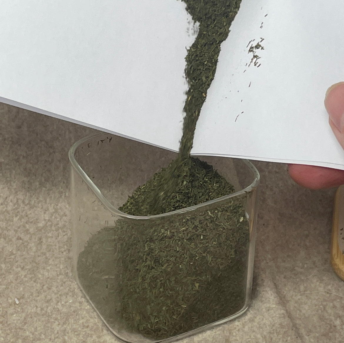 Spices being poured into an empty Mystic Nomad Dream Mist wax melt jar to show its repurposed use