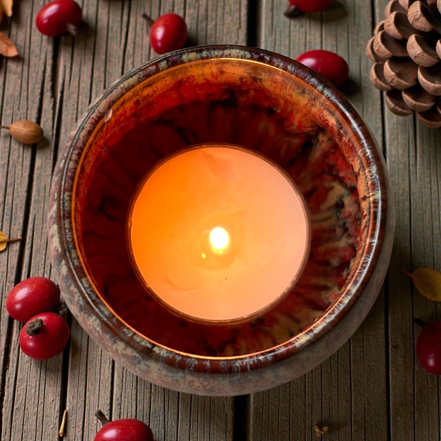 Top view of a Warm Ember aromatherapy candle tea light in a ceramic holder, releasing essential oil fragrance for focus and calm.