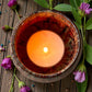 Top view of a single Wildflower Meadow aromatherapy tea light in a ceramic holder, scented with floral essential oils.