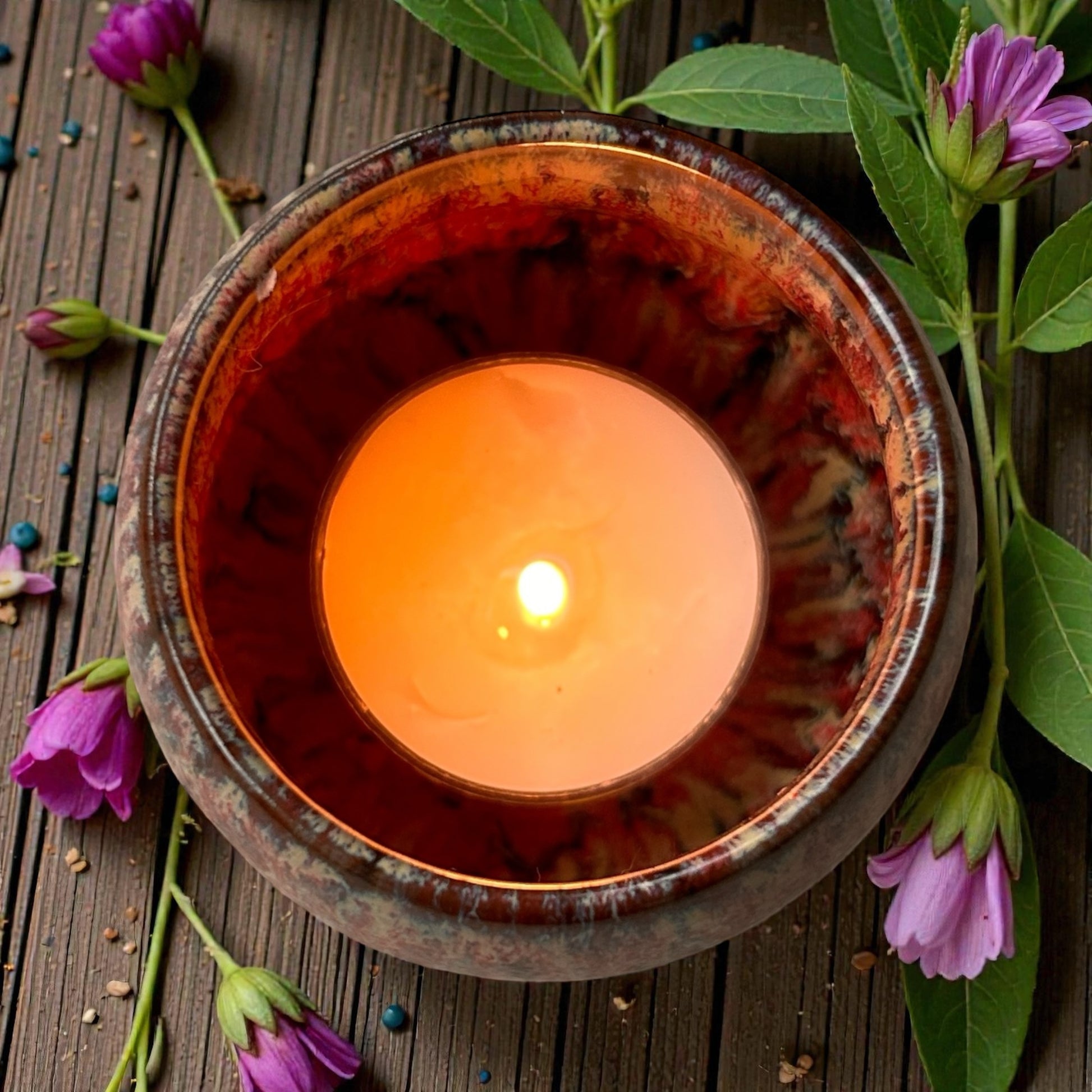 Top view of a single Wildflower Meadow aromatherapy tea light in a ceramic holder, scented with floral essential oils.
